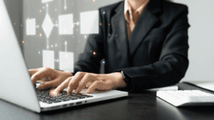 Profesional en traje de oficina utilizando un portátil para crear procesos corporativos, simbolizando la eficiencia y productividad en el entorno laboral.